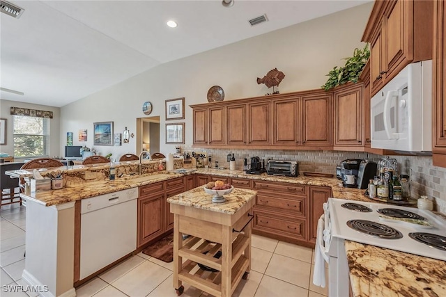 kitchen with lofted ceiling, a kitchen island, kitchen peninsula, sink, and white appliances