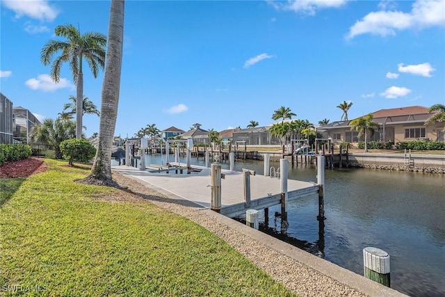 view of dock featuring a lawn and a water view