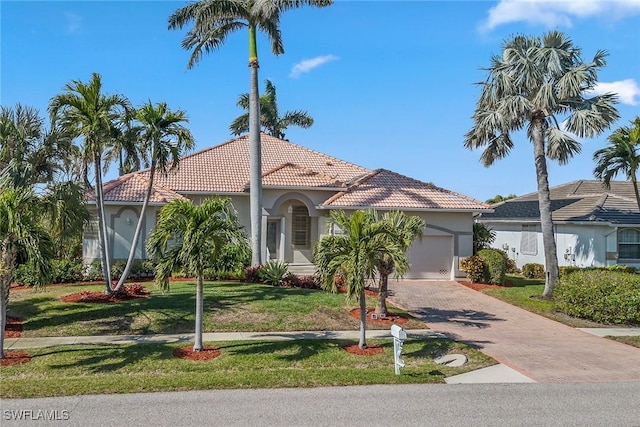 mediterranean / spanish house featuring a front lawn and a garage