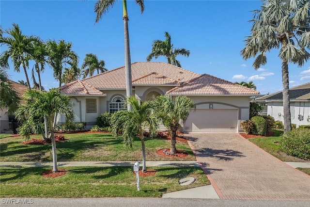 mediterranean / spanish house with a front lawn and a garage