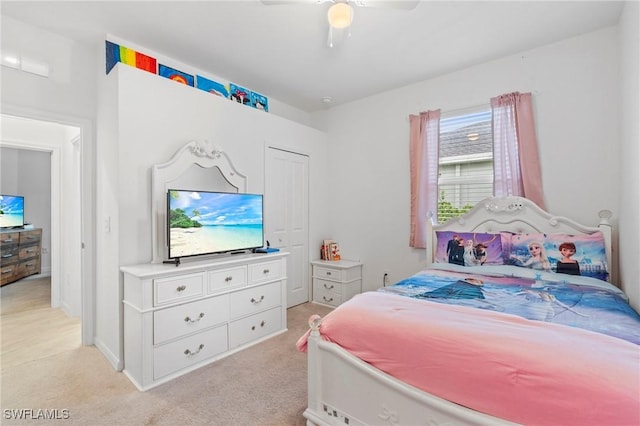 bedroom featuring ceiling fan, light colored carpet, and a closet