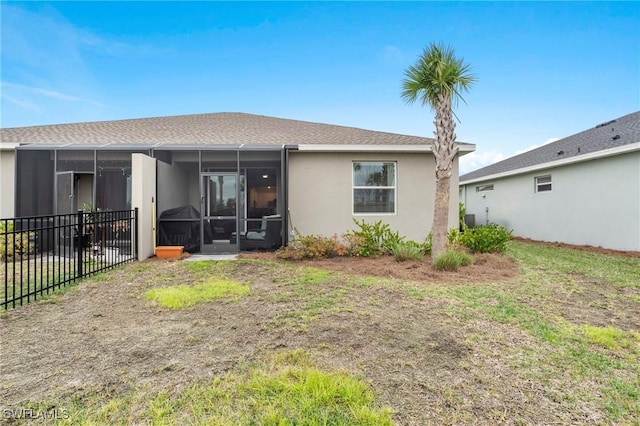 rear view of property with a yard and a sunroom