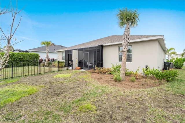 back of house featuring a yard and a sunroom