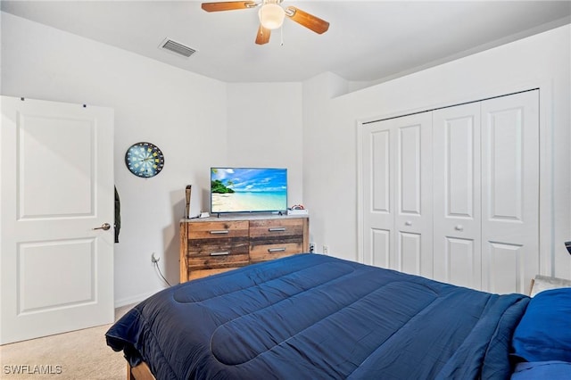 carpeted bedroom with ceiling fan and a closet