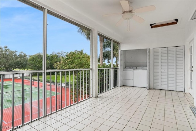 unfurnished sunroom featuring ceiling fan and washer and dryer