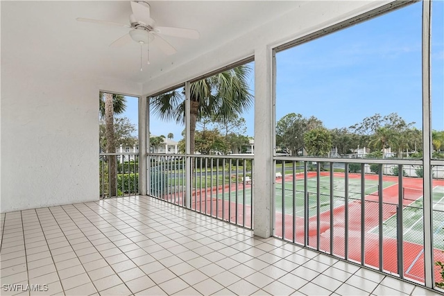 unfurnished sunroom featuring ceiling fan