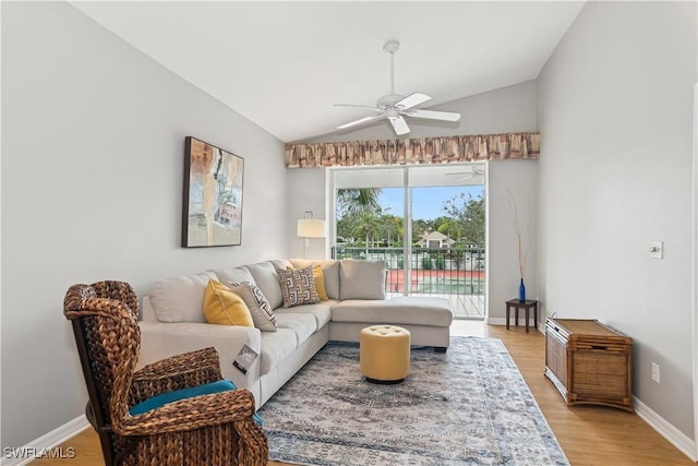 living area with lofted ceiling, light wood-style flooring, baseboards, and a ceiling fan