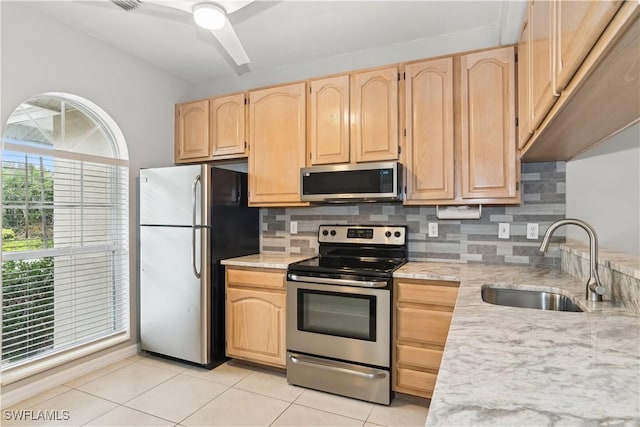 kitchen with tasteful backsplash, sink, appliances with stainless steel finishes, light tile patterned floors, and light brown cabinetry