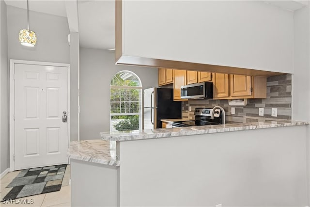 kitchen with kitchen peninsula, appliances with stainless steel finishes, backsplash, light tile patterned flooring, and light stone counters