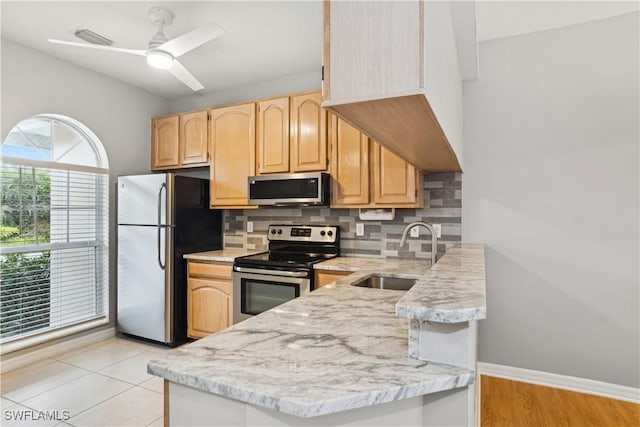 kitchen with tasteful backsplash, ceiling fan, sink, appliances with stainless steel finishes, and light brown cabinets