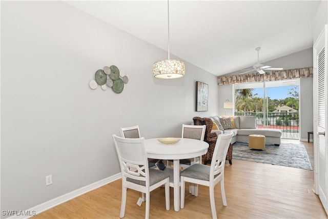 dining space featuring ceiling fan, light hardwood / wood-style floors, and vaulted ceiling