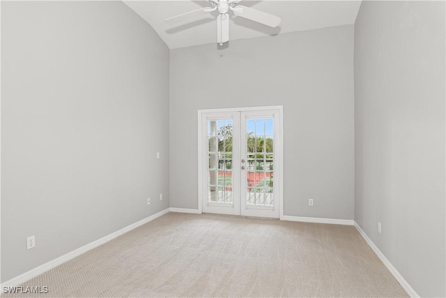 carpeted spare room with ceiling fan, french doors, and vaulted ceiling