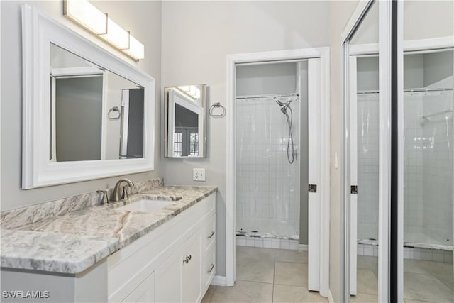 bathroom featuring walk in shower, vanity, and tile patterned flooring