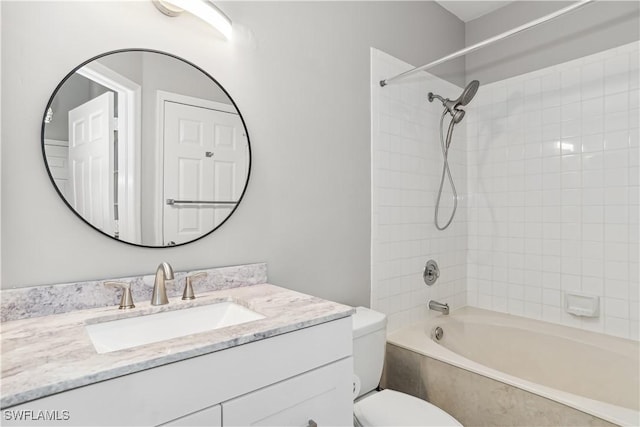 full bathroom featuring toilet, tiled shower / bath, and vanity