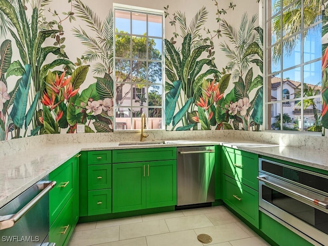 kitchen featuring light stone counters, green cabinetry, and appliances with stainless steel finishes