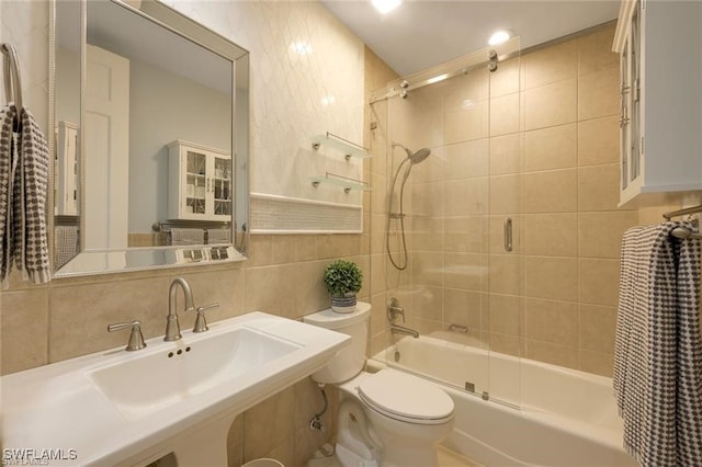 full bathroom with sink, backsplash, bath / shower combo with glass door, toilet, and tile walls