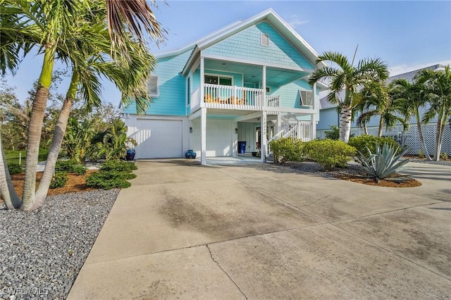 coastal inspired home featuring a balcony and a garage