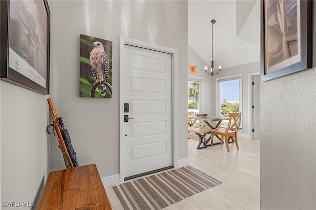 entryway featuring lofted ceiling, a notable chandelier, and light hardwood / wood-style floors