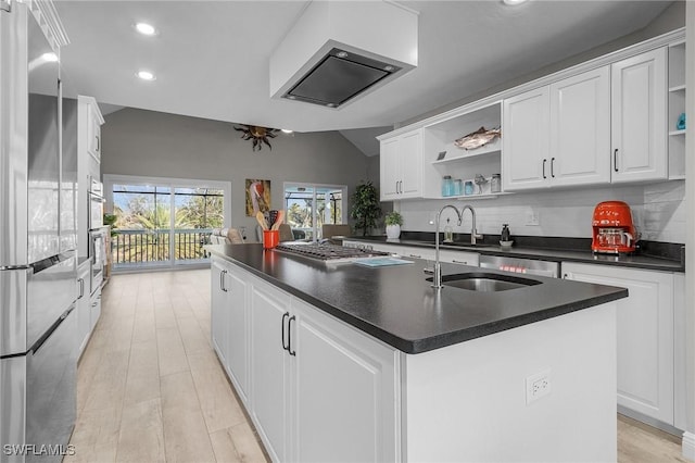 kitchen featuring sink, stainless steel appliances, white cabinetry, and an island with sink