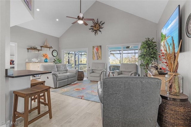 living room featuring high vaulted ceiling, ceiling fan, and light hardwood / wood-style flooring