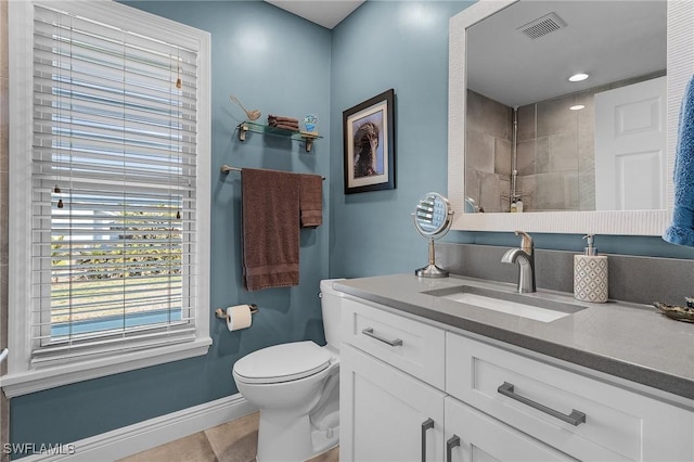 bathroom with vanity, a tile shower, tile patterned flooring, and toilet