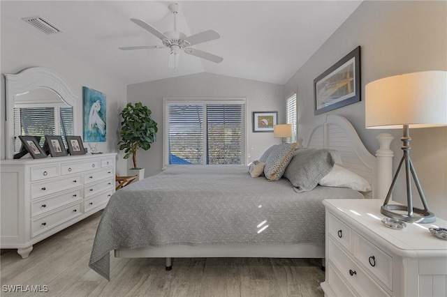 bedroom with ceiling fan, light hardwood / wood-style flooring, and lofted ceiling