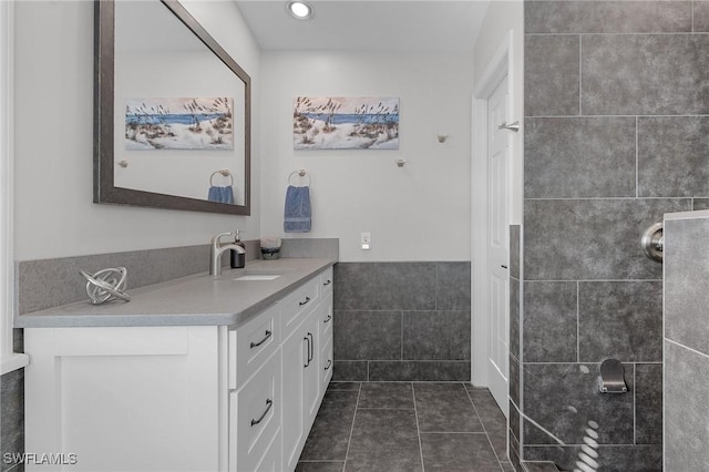 bathroom featuring tile walls, tile patterned floors, and vanity