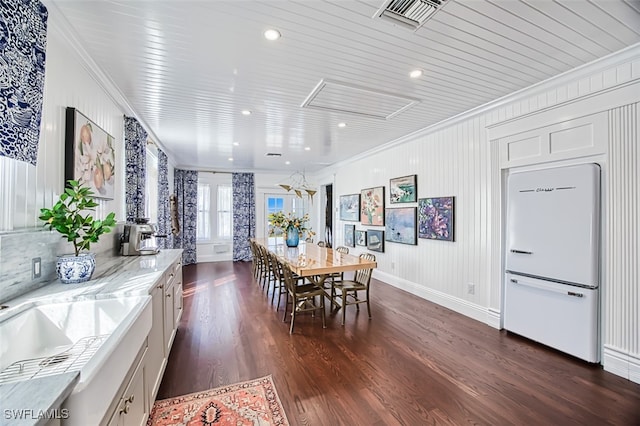 dining area featuring crown molding and dark hardwood / wood-style flooring