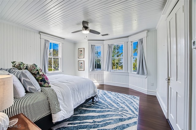 bedroom with dark hardwood / wood-style flooring, crown molding, and ceiling fan