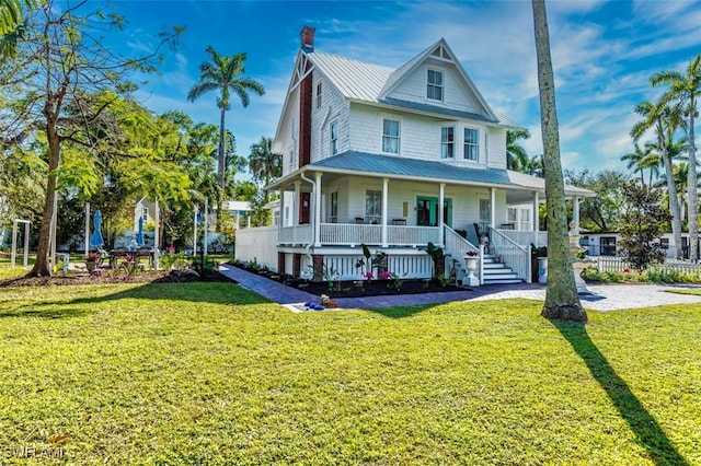 country-style home featuring covered porch and a front lawn