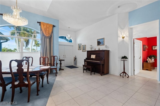 tiled dining area featuring an inviting chandelier and a high ceiling