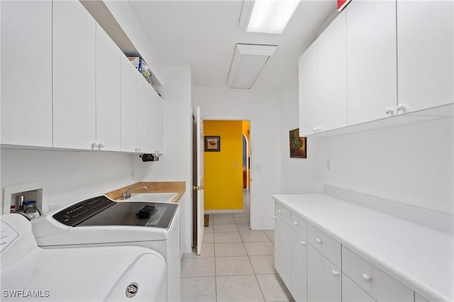 clothes washing area featuring separate washer and dryer, sink, light tile patterned floors, and cabinets