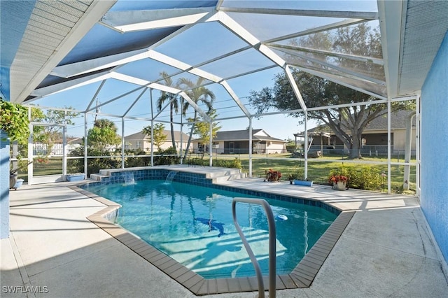 view of pool with a patio, pool water feature, and glass enclosure