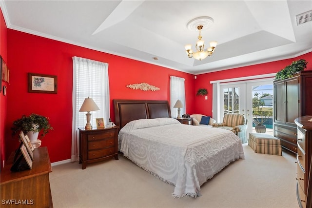 bedroom with carpet floors, a chandelier, access to exterior, a raised ceiling, and french doors