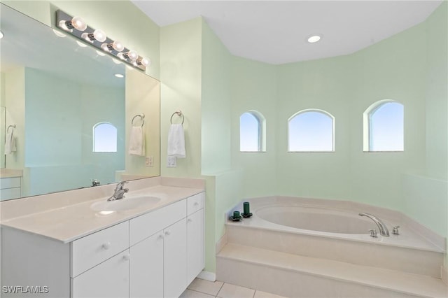 bathroom featuring tile patterned floors, vanity, and a bath