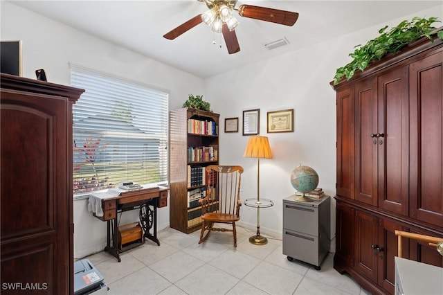 living area with light tile patterned floors and ceiling fan