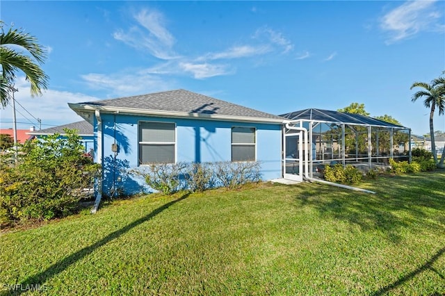 back of property featuring a yard and glass enclosure