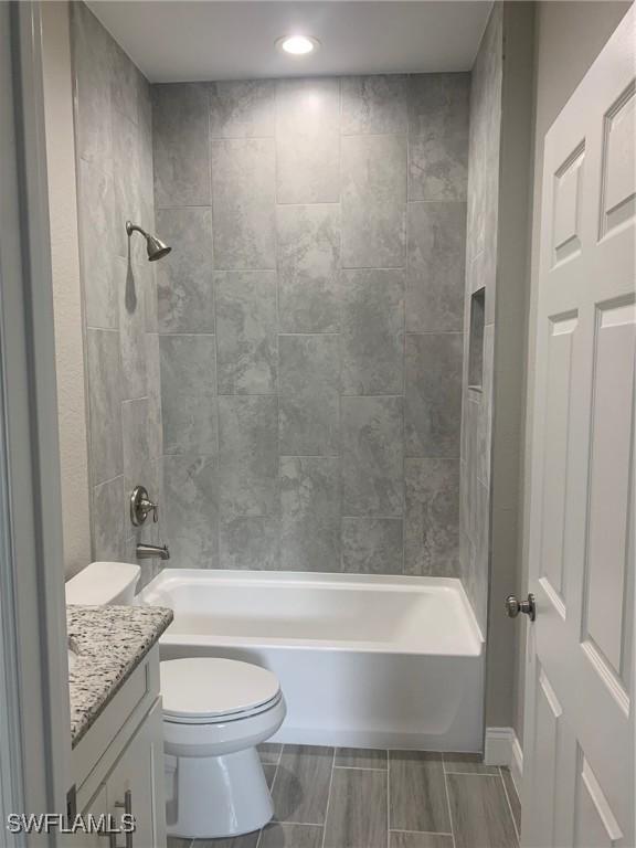 bathroom featuring toilet, bathtub / shower combination, and vanity