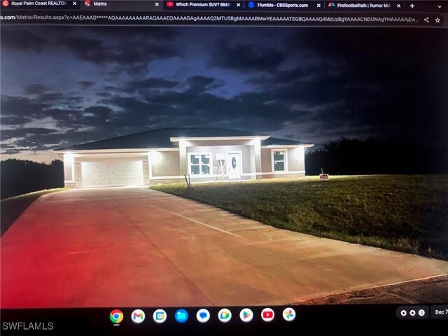 view of front of house featuring a front lawn, concrete driveway, and an attached garage