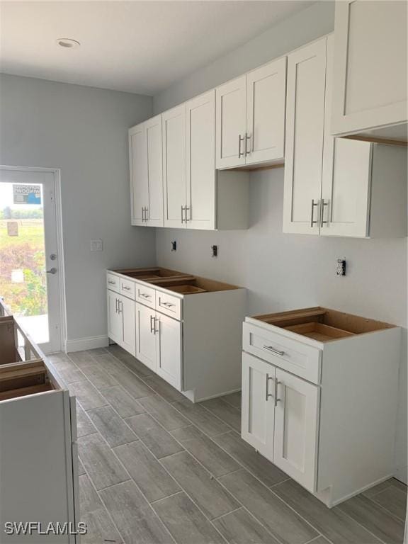 laundry area featuring baseboards and wood tiled floor