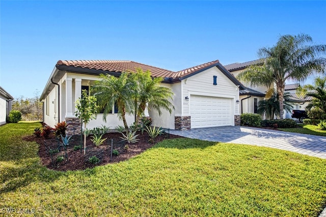 mediterranean / spanish home featuring a front lawn and a garage