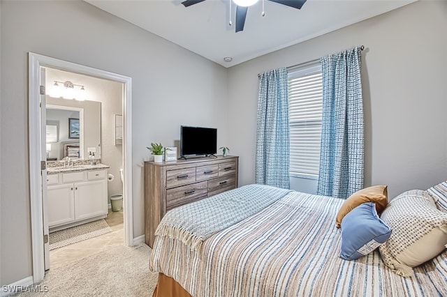 bedroom featuring ceiling fan, connected bathroom, light colored carpet, and sink