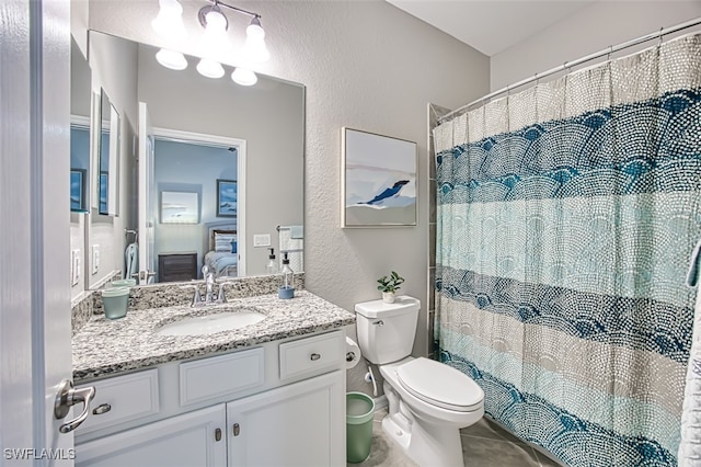 bathroom with curtained shower, toilet, vanity, and tile patterned flooring