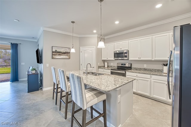 kitchen with a kitchen bar, white cabinetry, stainless steel appliances, sink, and a kitchen island with sink