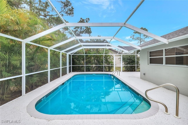 view of swimming pool featuring a patio area and glass enclosure