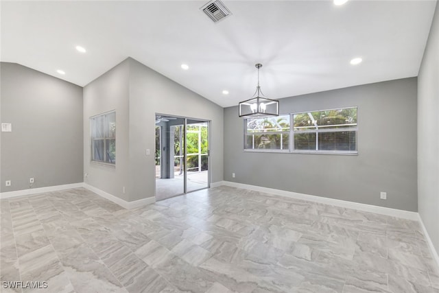 spare room with lofted ceiling and a notable chandelier