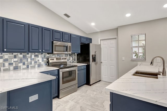 kitchen featuring vaulted ceiling, backsplash, blue cabinetry, appliances with stainless steel finishes, and sink