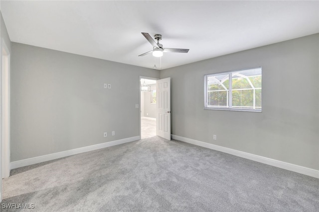 spare room with light colored carpet and ceiling fan