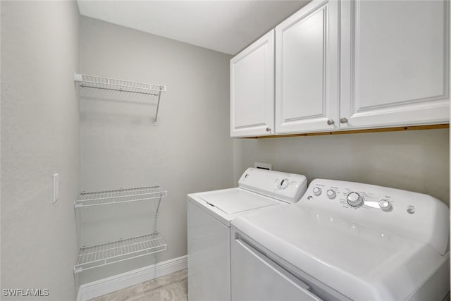 laundry area with washer and dryer and cabinets