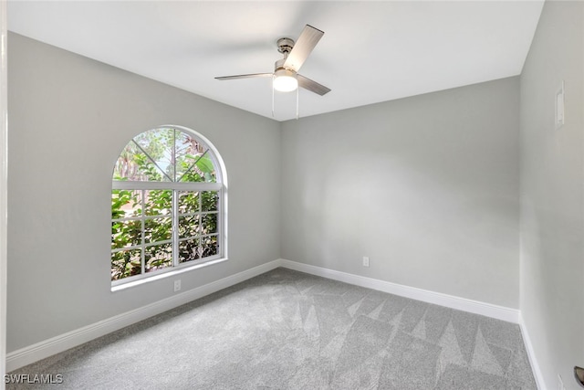 carpeted spare room featuring ceiling fan